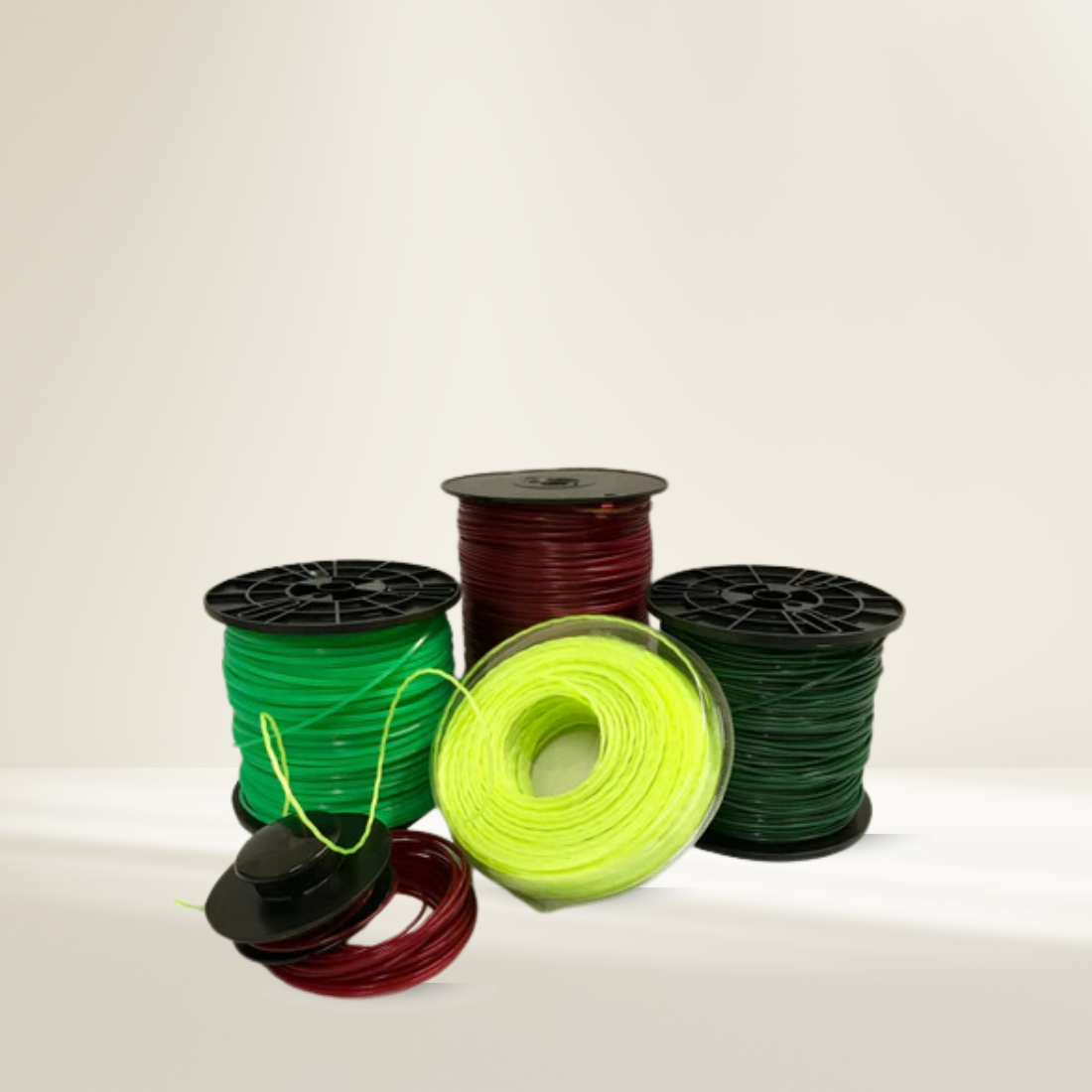 Spools of green, red, and black thread on a beige background